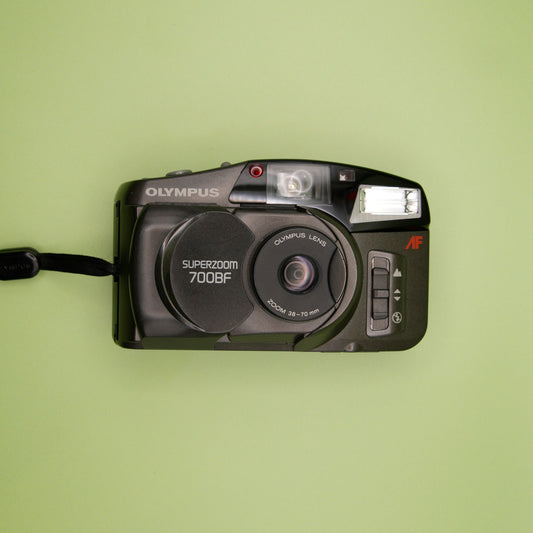 Olympus Superzoom 700BF camera on a green background